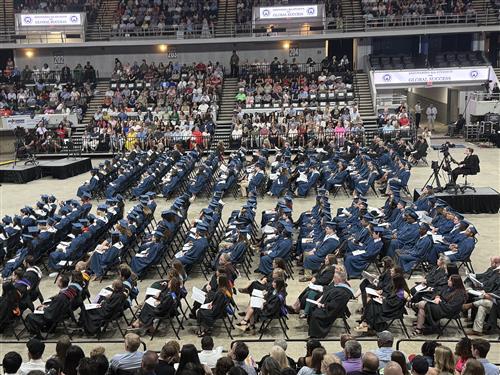 side view of graduates on arena floor